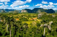 Prima oprire este la Mirador de los Jazmines, de unde putem admira si fotografia peisajul minunat, dominat de vegetatie luxurianta si de mogotes, dealuri inalte de pana la 300 m