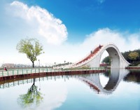 Situat in delta raului Yangtze, cunoscut sub numele de la Venetia Orientului, orasul este renumit pentru podurile frumoase de piatra, pagodele si gradinile meticulos proiectate in